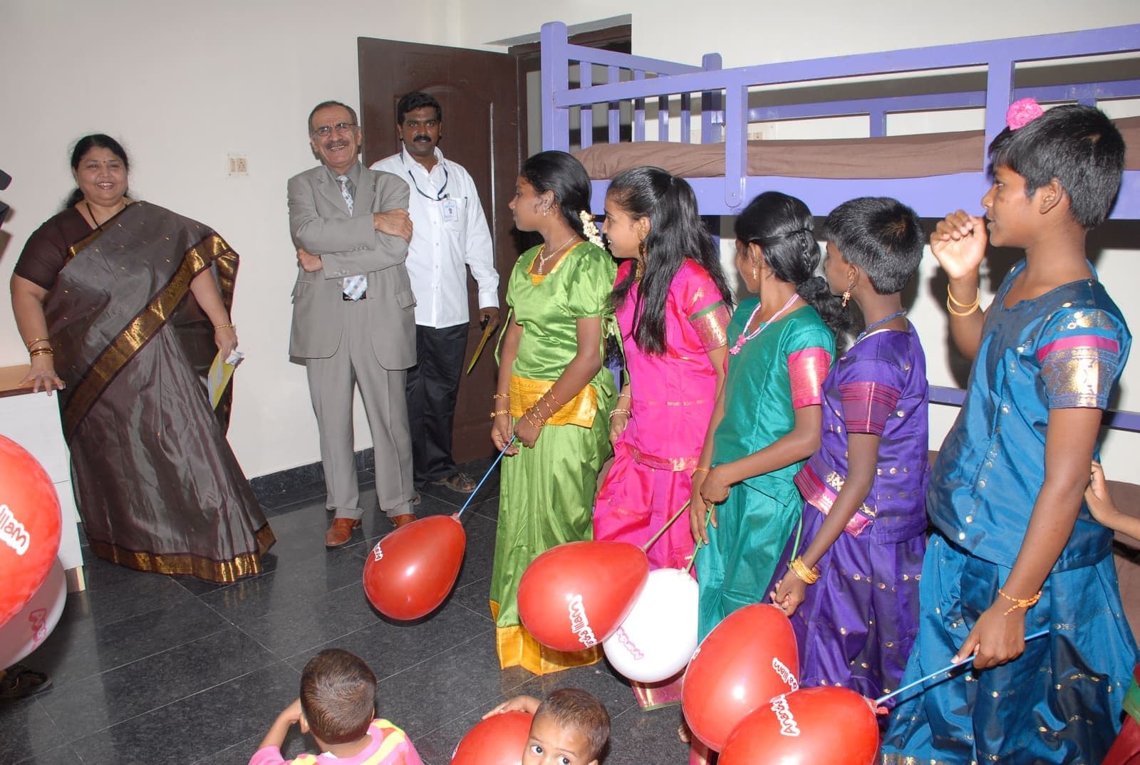 Children welcoming guests with balloons at a CHES event