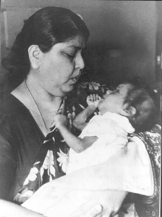 Dr. Manorama Pinagapany caring for a child in an archival photograph